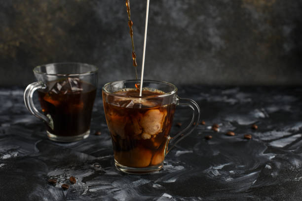 istock Two glass cups with cold coffee. Black iced coffee with milk. 1201391582