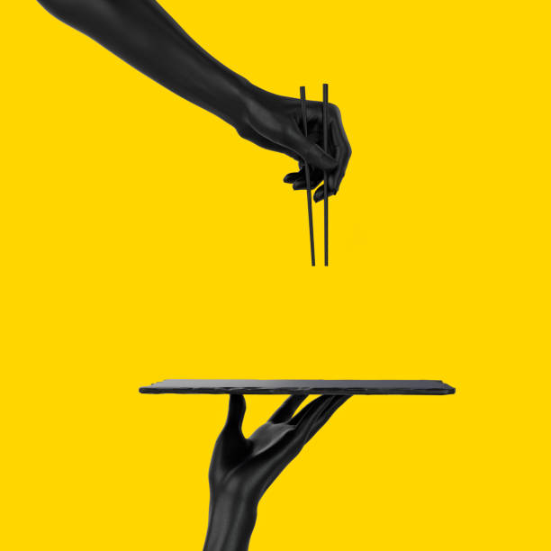 istock Abstract sushi bar concept background. Black hands using chopsticks and sushi dish isolated on yellow, 3d illustration. 1201393339
