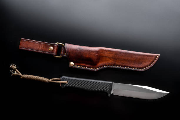 istock A modern hunting knife and a leather case for him on a dark background. Melee weapons for hunting and self-defense. The instrument of crime. 1201393605