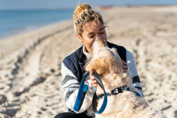 istock Young Woman with her dog on the beach 1201397541
