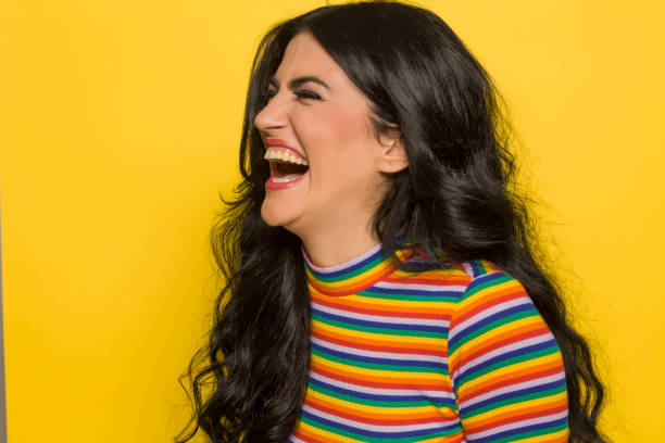 istock Attractive laughing brunette on yellow background 1201398242