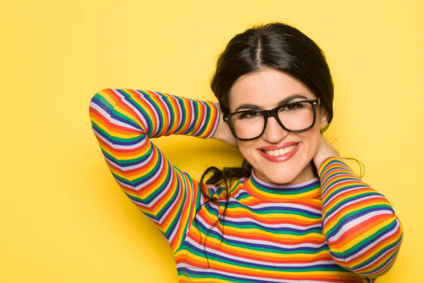 istock Attractive smiling brunette with glasses on yellow background 1201398278