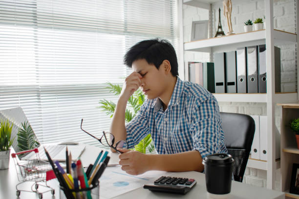 istock Young Asian business have headaches and are sick at work. 1201401256