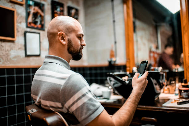 istock Young modern man using a mobile phone to take a selfie in a barber shop 1201401589