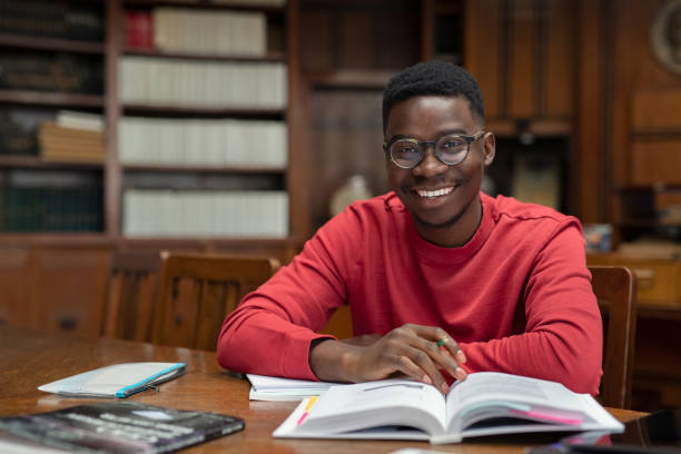 étudiant heureux d'université dans la bibliothèque - smart casual cheerful content image photos et images de collection