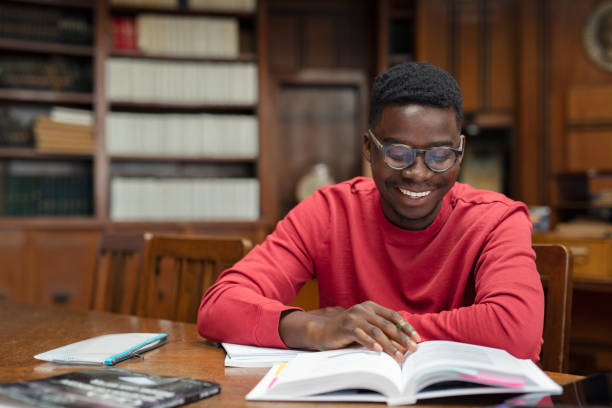 glückliche universität studenten lesen in der bibliothek - reading and writing exam preparation education stock-fotos und bilder