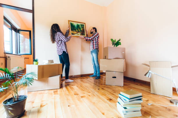 Excited couple hanging picture on wall