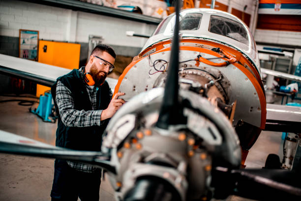 istock Aircraft mechanic working on a front engine assembly of a small aircraft in a hangar 1201405821