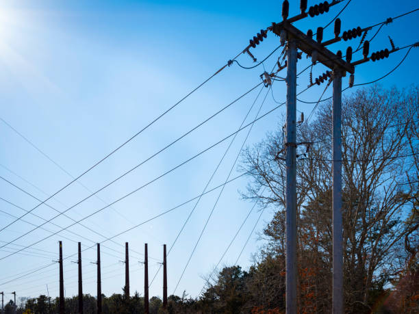 istock Electric wires crossing between many poles against sunny blue sky 1201406109