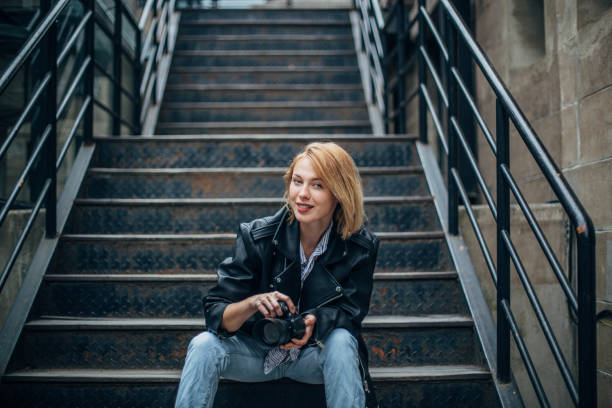 istock One pretty woman in leather jacket taking pictures 1201407409