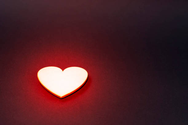 istock Sparkling golden heart on a dark background. Red backlight 1201408889