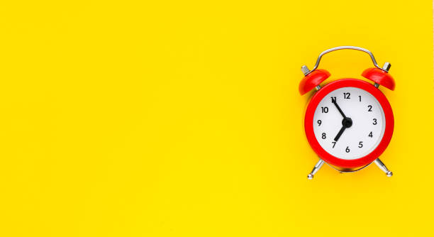 istock Close up red alarm clock on yellow background. View from above. 1201410537