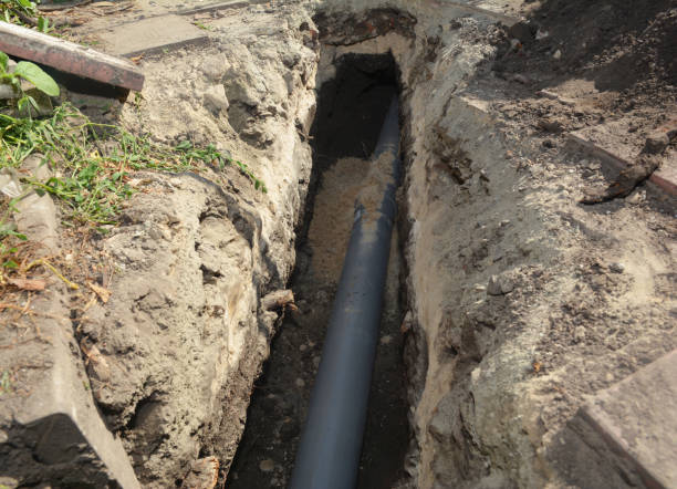установка канализационной трубы в грунтовой траншее. установка канализационных труб дома - wastewater сто�ковые фото и изображения