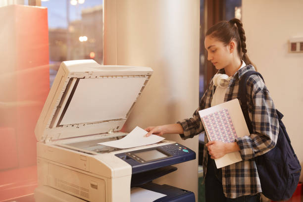 istock Student making copy of her report 1201412616