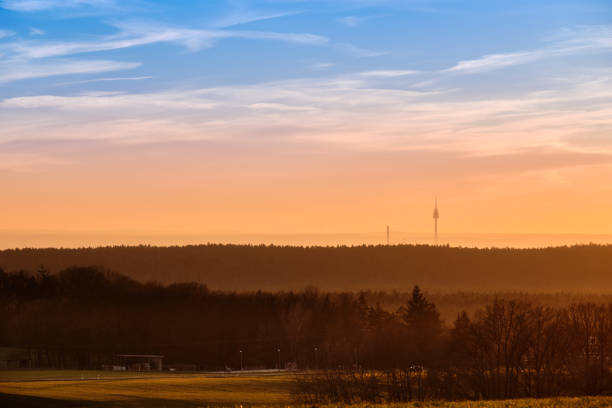 Beautiful rural sunset landscape with the television tower of Nuremberg in the background. Seen in Bavaria, Germany in January from Tauchersreuth.