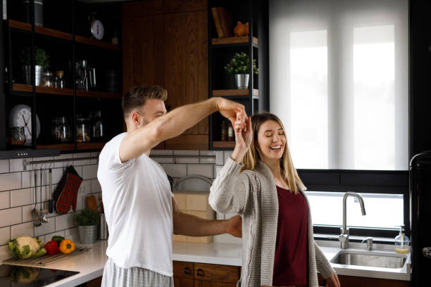 istock Happy young couple enjoying time together at home dancing 1201414696