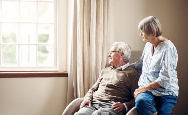 Real comfort is a life lived together Shot of a senior couple looking thoughtfully out of a window at home alzheimers disease stock pictures, royalty-free photos & images