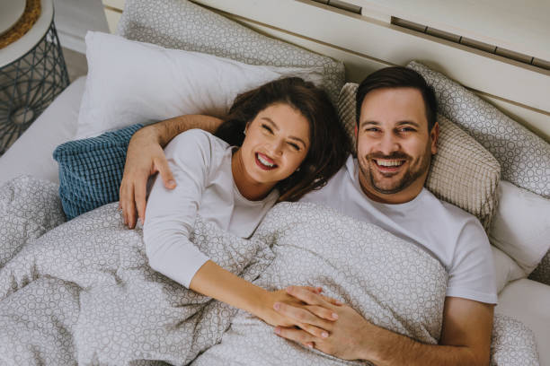 istock Beautiful happy young couple lying in bed and hugging 1201415996