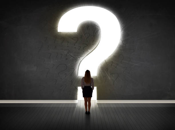 istock Business woman looking at wall with a bright question mark 1201417105