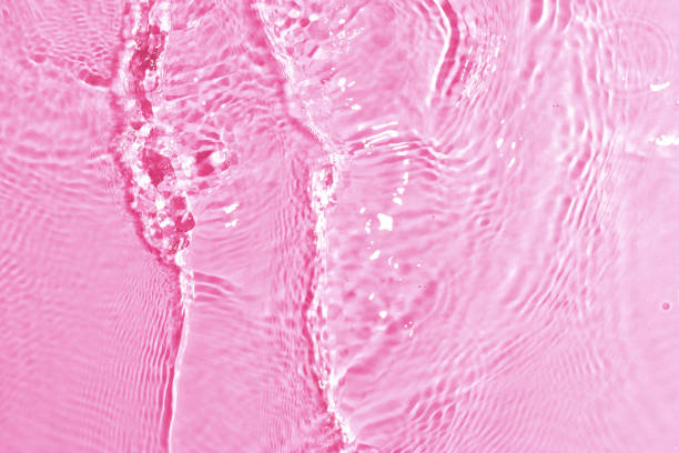 texture of splashing clean water on pink background stock photo