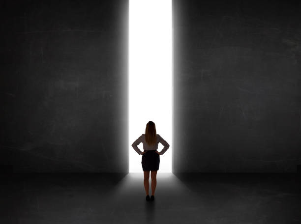 istock Business person looking at wall with light tunnel opening 1201417134