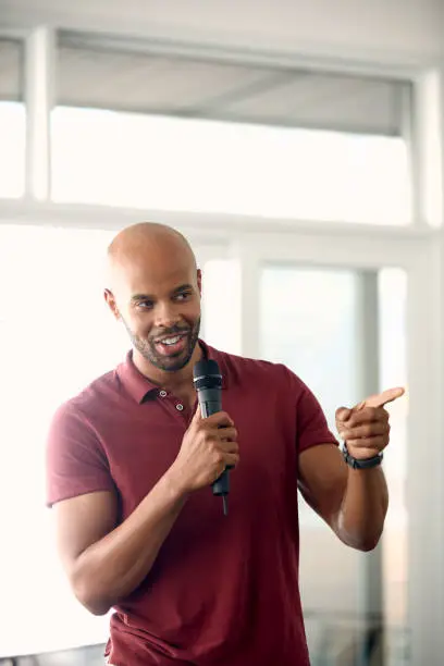 Cropped shot of a handsome young man speaking over a microphone
