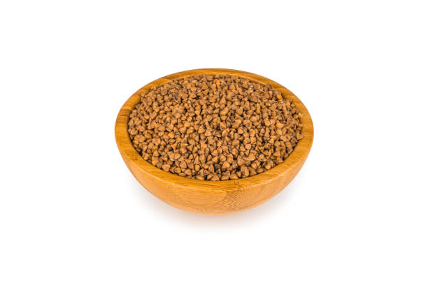 istock Raw buckwheat groats in a bamboo cup isolated on white with a light shadow. Diet Food Concept. 1201418532