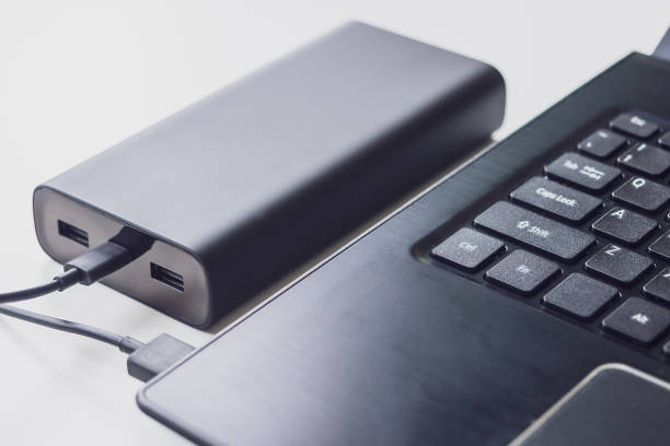 istock An open laptop is charged using a power bank via a cable. Portable modern devices. External battery, cable, USB and laptop, close-up 1201419832