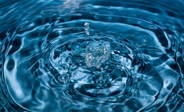 istock water drop splash in a glass blue colored. 1201420050
