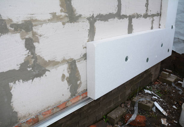 istock External house wall insulation with styrofoam. Installing rigid foam insulation board on house wall outdoors. Attach rigid foam insulation to a house wall 1201422342
