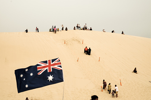 Groups of tourists were playing and sliding sand boards on sand dunes at Port Stephens