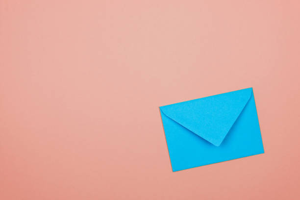 istock blue closed envelope in corner of a pink background 1201427183