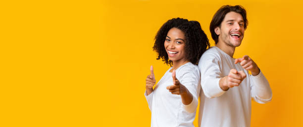 istock Cheerful interracial couple pointing at camera and laughing 1201429577