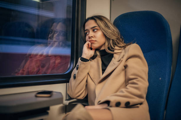 istock Woman sitting in train and looking through the window 1201429825