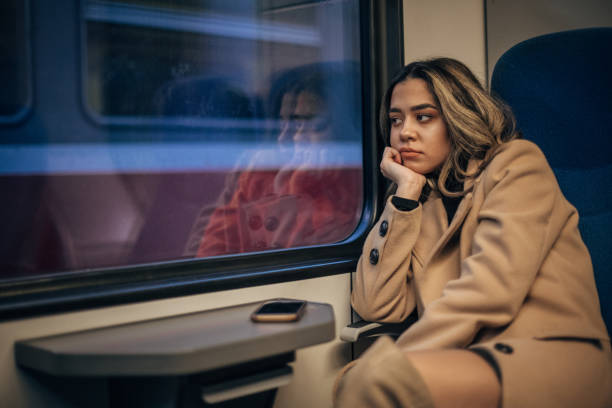 istock One woman sitting in train and looking through the window 1201429848