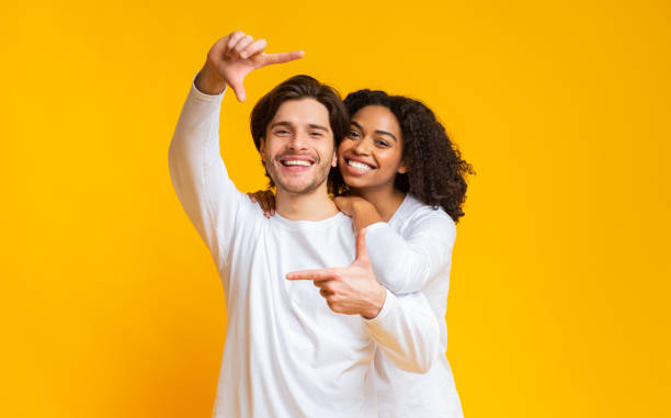 istock Romantic interracial couple making frame with hands and embracing 1201429980