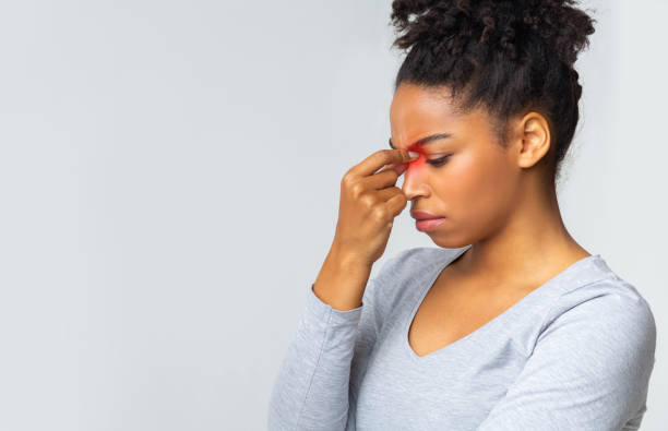 istock Sad young woman touching her nose bridge 1201430087