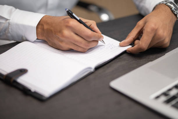 istock Businessman writing at the desk 1201430837