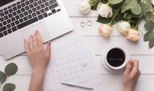 istock Female hands preparing for marriage, using laptop, paper calendar 1201431026