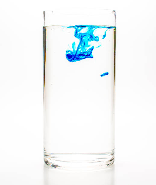istock Blue food coloring diffuse in water inside glass 1201431202