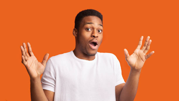 istock Confused afro guy raising his hands and looking at camera 1201431420