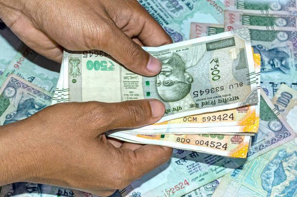 istock Hand holds and counting two and five hundred rupees Indian currency. 1201435679