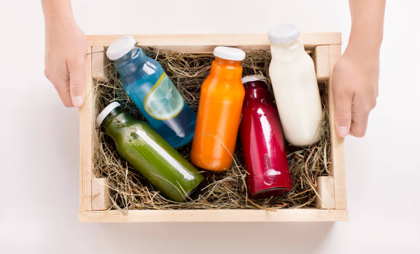 istock Female holding wooden box with Different flavoured detox drinks 1201435822