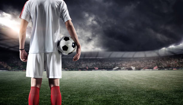 istock Football player with ball in the stadium 1201436792