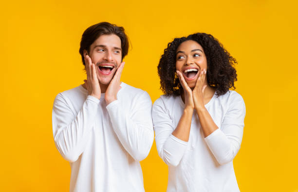 istock Shocked interracial couple exclaiming and touching cheeks in amazement 1201437687