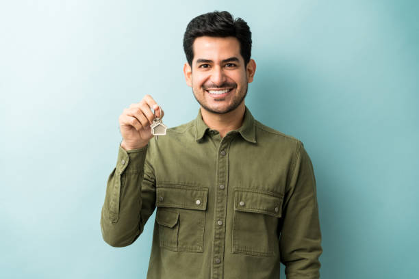 Man With House Keys Against Blue Background