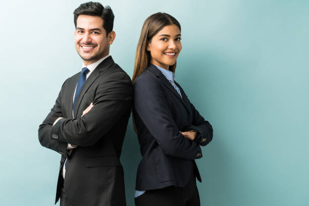 Business Colleagues Standing With Arms Crossed In Studio Latin confident professionals in suit standing against isolated background arms crossed stock pictures, royalty-free photos & images