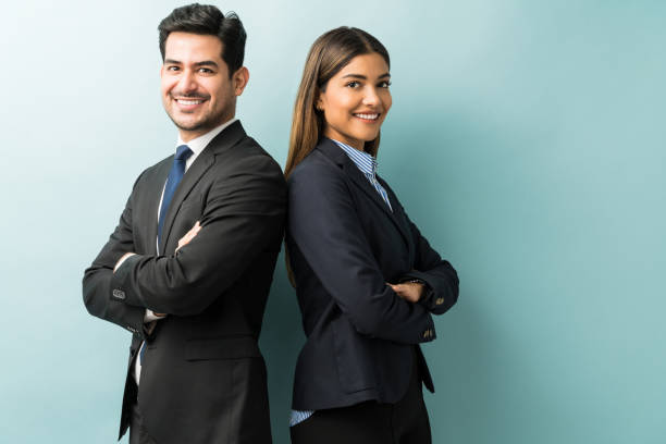 Business Colleagues Standing With Arms Crossed In Studio Latin confident professionals in suit standing against isolated background woman arms folded stock pictures, royalty-free photos & images