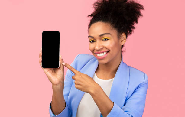 istock Black girl showing blank black cell phone screen 1201445336