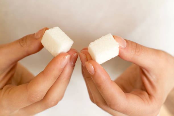istock young woman holding sugar cubes 1201446050